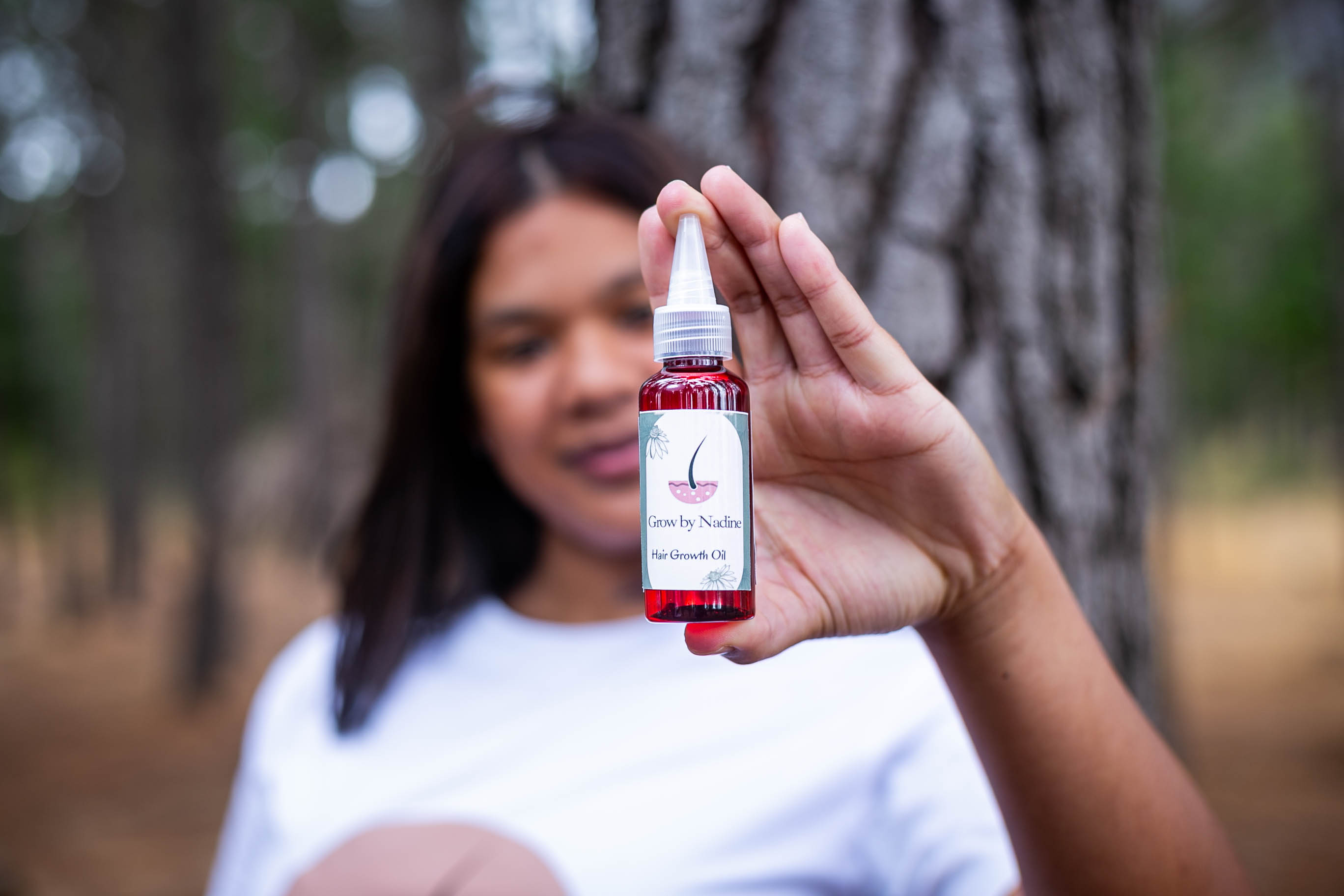 Grow by Nadine Hair Growth Oil held outdoors
